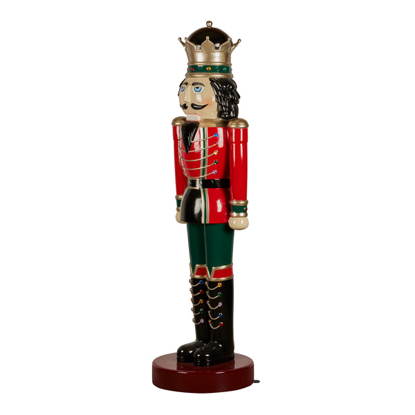 Decorative red and green nutcracker figurine with a crown on a white background